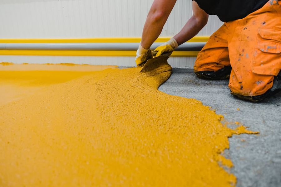 Floor coating being spread across a prepared slab