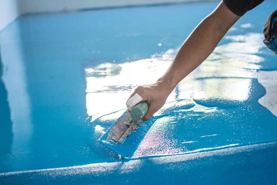 Resin being spread across a floor with a trowel