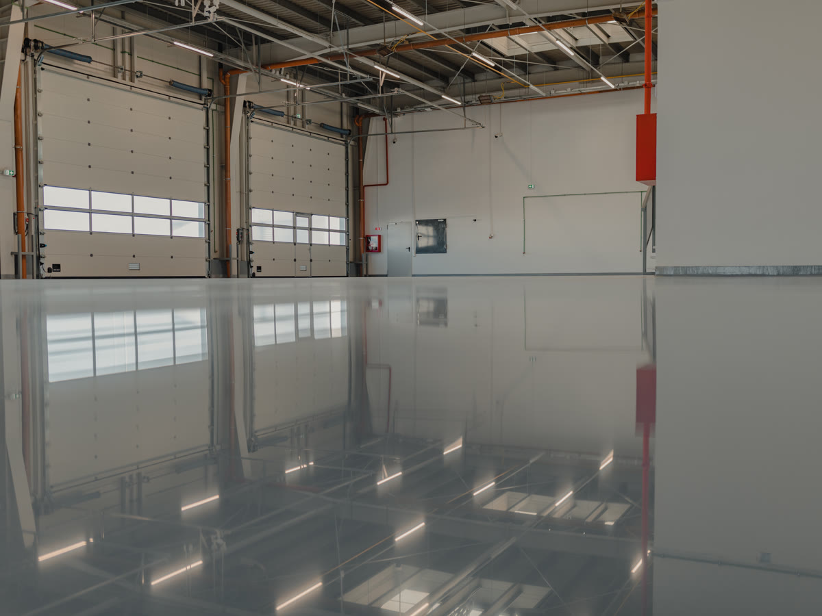 Reflective grey resin floor running the length of an industrial unit