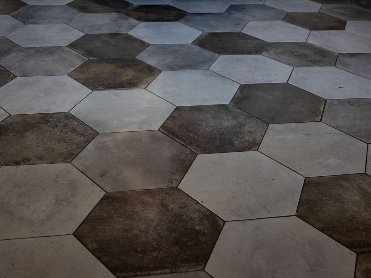 Hexagonal stone floor tiles laid in warm grey and brown